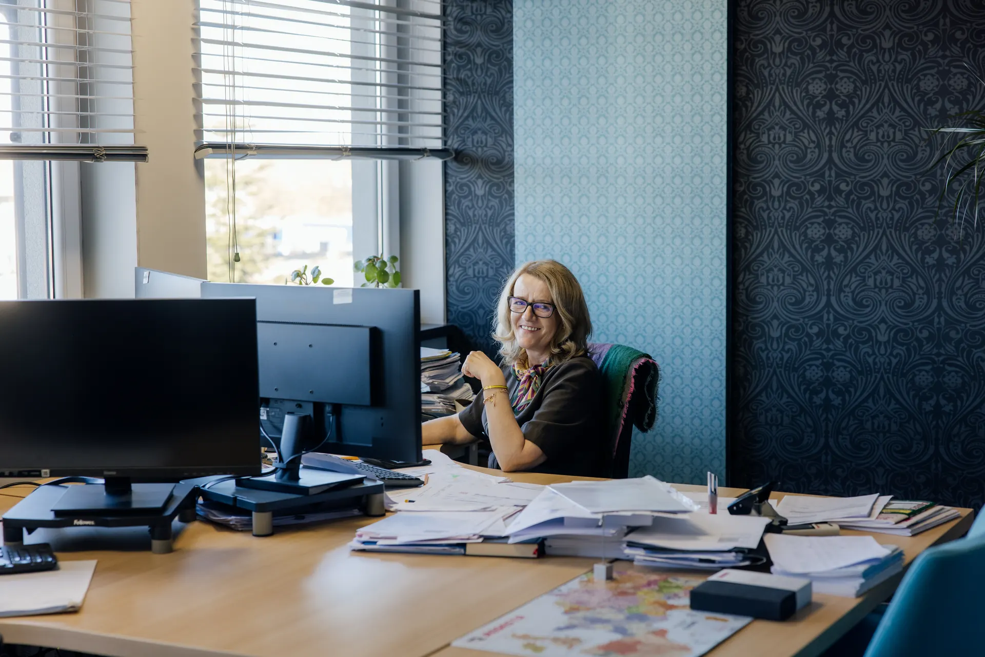 Pracowniczka Regesta przy biurku z dokumentami